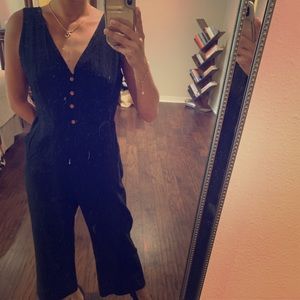 Black sleeveless jumpsuit with decorative buttons